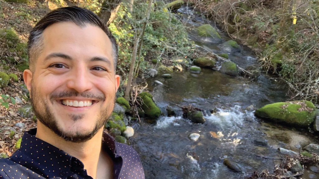 Michael Tuso smiling selfie in front of a stream.