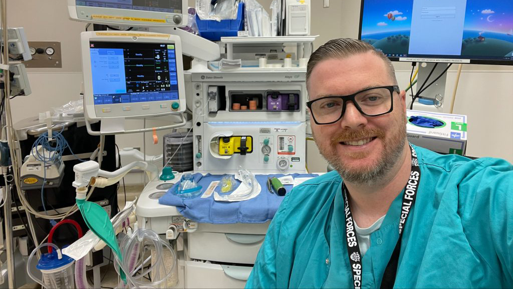 Nurse Dan Lorden smiling selfie in front of his work station.