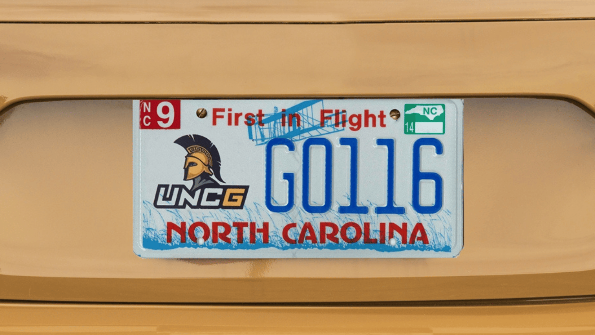 Gold car with a closeup of a UNCG license plate